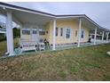 Charming single-story home with carport, well-maintained landscaping and cozy outdoor seating area at 35020 Colony Hills Dr, Zephyrhills, FL 33541