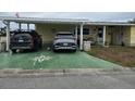 Exterior view featuring a covered driveway with two cars parked and a decorative compass on the concrete at 35020 Colony Hills Dr, Zephyrhills, FL 33541