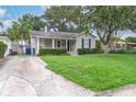 Cozy home with green lawn and driveway, surrounded by mature trees and lush landscaping at 3503 W Palmira Ave, Tampa, FL 33629