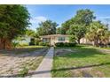 Inviting single-story home with lush greenery, a cozy front porch, and a charming walkway leading to the entrance at 3622 W Mullen Ave, Tampa, FL 33609