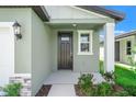 Close-up of the front door featuring a covered entry, side window, and welcoming facade at 3655 Moscato Dr, Brooksville, FL 34602