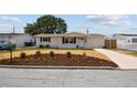 Charming single-story home featuring a well-manicured lawn, fresh mulch, and mature trees at 3850 Carioca Rd, Holiday, FL 34691