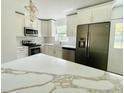 This open-concept kitchen features modern appliances and quartz countertops, with ample natural light at 4415 Tuna Dr, Tampa, FL 33617