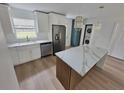 Modern kitchen boasts stainless steel appliances, quartz countertops, island, and stylish pendant lighting at 4415 Tuna Dr, Tampa, FL 33617
