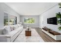 Bright living room boasts hardwood floors, a large window, and a comfortable sofa perfect for relaxing or entertaining guests at 4925 Alcazar S Way, St Petersburg, FL 33712