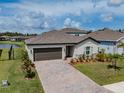 Aerial view of a charming home with a brick driveway and manicured lawn in a suburban neighborhood at 5329 Senza Trl, Palmetto, FL 34221