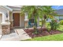 Inviting front porch features stone accents, a cozy seating area, and lush landscaping at 5830 100Th E Ave, Parrish, FL 34219