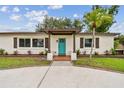 Close-up of home's inviting entrance with twisted columns and a vibrant blue front door at 5934 51St N Ave, Kenneth City, FL 33709