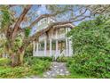 Inviting two-story home with covered porches surrounded by lush landscaping and majestic live oak trees at 6220 Bayshore Blvd, Tampa, FL 33611