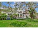 Sprawling two-story home showcasing an expansive porch and mature trees at 6220 Bayshore Blvd, Tampa, FL 33611