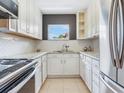 Bright kitchen features white cabinets, stainless steel appliances, and natural light at 6360 1St N St # 202, St Petersburg, FL 33702