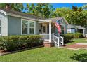Well-maintained home featuring an inviting front porch, neat landscaping, and a brick walkway at 702 W Kentucky Ave, Tampa, FL 33603