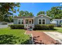 Charming home with a welcoming front porch, tidy landscaping, and brick walkway at 702 W Kentucky Ave, Tampa, FL 33603
