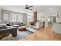 Open floor plan with hardwood floors, a cozy sectional, and a brick support column at 702 W Kentucky Ave, Tampa, FL 33603