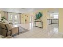 Open-concept living area with tile flooring and access to a bright kitchen at 7401 Islander Ln, Hudson, FL 34667