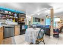 Bright eat-in kitchen with appliances, tile flooring, and views to the living area at 7441 Cypress Dr, New Port Richey, FL 34653