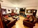 Comfortable living room with hardwood floors, brick fireplace, and stylish furnishings at 8834 Whispering Oaks Trl, New Port Richey, FL 34654