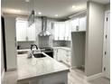 Modern kitchen with white cabinets, stainless steel appliances, and a quartz countertop island at 9005 W Flora St, Tampa, FL 33615