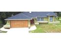 Charming single-story home featuring a two-car garage, manicured lawn and appealing architectural details at 10287 Fordham St, Spring Hill, FL 34608