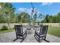 Backyard featuring a custom stone fire pit with built in seating at 10399 Boyette Brook St, Riverview, FL 33569