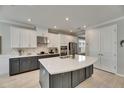 Modern kitchen boasts a large island, stainless steel appliances, and sleek gray and white cabinetry at 10399 Boyette Brook St, Riverview, FL 33569