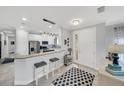 Open-concept kitchen with stainless appliances, white cabinetry, pendant lighting and seating at the breakfast bar at 10450 Highland Park Pl, Palmetto, FL 34221