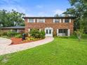 Charming brick home with lush landscaping, a brick walkway, and manicured lawn at 12603 Corral Rd, Tampa, FL 33626
