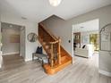 Inviting foyer showcasing a wooden staircase with black iron railings and newly installed vinyl flooring at 12603 Corral Rd, Tampa, FL 33626