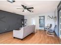 Comfortable living room featuring a sofa, chairs, sliding glass doors, and modern ceiling fan at 15906 Country Farm Pl, Tampa, FL 33624