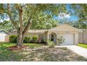 Charming single-story home featuring a well-maintained lawn and mature trees at 1600 Amberlea N Dr, Dunedin, FL 34698