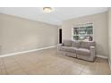 Inviting living room with neutral-toned walls, tile flooring, and a comfortable sofa at 1600 Amberlea N Dr, Dunedin, FL 34698