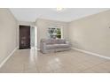 Inviting living room with neutral-toned walls, tile flooring, and a comfortable sofa at 1600 Amberlea N Dr, Dunedin, FL 34698