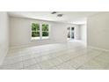 Spacious living room with tile flooring, bright natural light, and sliding glass doors that lead to the backyard at 16138 Manorwood Cir, Tampa, FL 33624