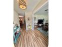 Bright entryway with wood floors and view to living room with a television at 1814 Driftwood S Cir, Oldsmar, FL 34677