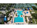 Aerial view of a large community pool with a kiddie pool area, lounge chairs, and mature landscaping at 19309 Seacove Dr, Lutz, FL 33558