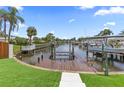View of private dock on canal featuring boat lift, green space, and direct water access at 1964 Tanglewood Ne Dr, St Petersburg, FL 33702