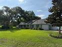 Spacious property featuring a well-kept lawn, mature trees, and a charming home, blending comfort and nature at 2005 Capri Rd, Valrico, FL 33594