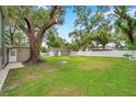 Spacious backyard with a detached garage and a large shade tree at 205 W Wheeler Rd, Seffner, FL 33584