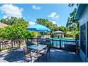 Backyard featuring a spacious deck with a table, chairs, and a refreshing swimming pool at 211 Arlington E Ave, Oldsmar, FL 34677