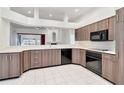 Open kitchen featuring sleek cabinets, modern appliances, and a breakfast bar overlooking the living area at 211 Arlington E Ave, Oldsmar, FL 34677
