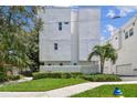 Shot of the exterior showcasing a grassy front yard with a modern townhouse in the background at 3100 W Paul Ave # 15, Tampa, FL 33611