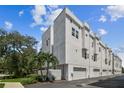 Exterior view of modern townhomes with white facades and attached garages under a bright sky at 3100 W Paul Ave # 15, Tampa, FL 33611
