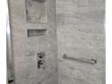 Updated shower with gray tile, built-in niche and shelving, and grab bar at 3123 29Th N Ave # 105, St Petersburg, FL 33713