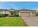 Charming home with a well-kept lawn, lush landscaping, and a convenient three-car garage at 31646 Baymont Loop, Wesley Chapel, FL 33543
