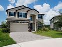 Charming two-story home featuring stone accents, a two-car garage, and a well-manicured lawn at 38120 Shale Stone Ct, Zephyrhills, FL 33540