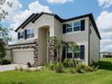 Charming two-story home featuring stone accents, a two-car garage, and a well-manicured lawn at 38120 Shale Stone Ct, Zephyrhills, FL 33540