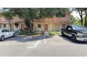 Exterior of a two-story townhome featuring reserved parking, a well-maintained facade, and mature trees at 4003 Oak Limb Ct, Tampa, FL 33614