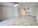 Bright and open living room with tile flooring, ceiling fan, and a glimpse of the staircase at 4003 Oak Limb Ct, Tampa, FL 33614