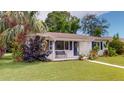 Charming home with a blue door, matching shutters, and a bench surrounded by lush greenery at 4300 16Th N Ave, St Petersburg, FL 33713