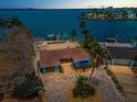 Waterfront home featuring lush landscaping, a private dock, and a brick driveway at 4381 Poinsettia Dr, St Pete Beach, FL 33706